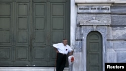 Seorang pensiunan menunggu di luar kantor cabang National Bank yang tutup di Athena (29/6). (Reuters/Alkis Konstantinidis)