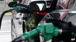 FILE - Gas is pumped into vehicles at a BP gas station in Hoboken, N.J., June 30, 2016. Federal regulators will review strict vehicle fuel efficiency standards finalized days before President Donald Trump took office.