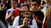 FILE - Exiled Tibetans pray during a protest rally to express solidarity with Tibetans who have self-immolated, in New Delhi, India, Nov. 28, 2012.