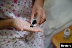 Seorang penderita kanker serviks sedang meminum obat di sebuah pusat perawatan di Beijing, China, 23 Juni 2016.