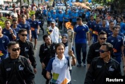 Atlet para games, Nanda Mei Sholihah, membawa obor dalam kirab obor Asian Games menjelang pelaksanaan Asian Games 2018, di Yogyakarta, Indonesia, 19 Juli 2018.