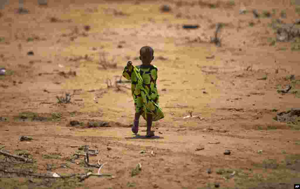 Seorang anak berjalan di desa Bandarero, Kenya utara dekat perbatasan Ethiopian yang dilanda kekeringan parah akibat kemarau.