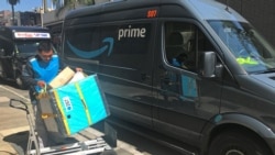 Un trabajador de Amazon carga un carro desde una furgoneta de reparto Prime en Los Ángeles, California, EE. UU.