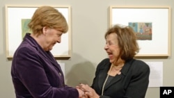 Artist Nelly Toll (r) shares a light moment with German Chancellor Angela Merkel as Merkel inaugurates the exhibition "Art from the Holocaust - 100 works from the Yad Vashem collection" in the German Historical Museum in Berlin, Jan. 25, 2016.