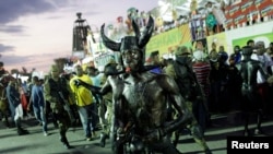 A reveler blows a whistle as he takes part in the National Carnival 2015 annual parade in Port-au-Prince, Feb. 15, 2015.