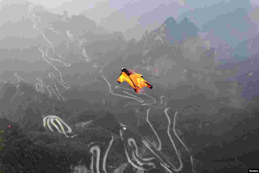 Seorang peserta lomba&nbsp;dengan pakaian terbang melompat dari Pegunungan Tianmen di Zhangjiajie, Hunan, China. 