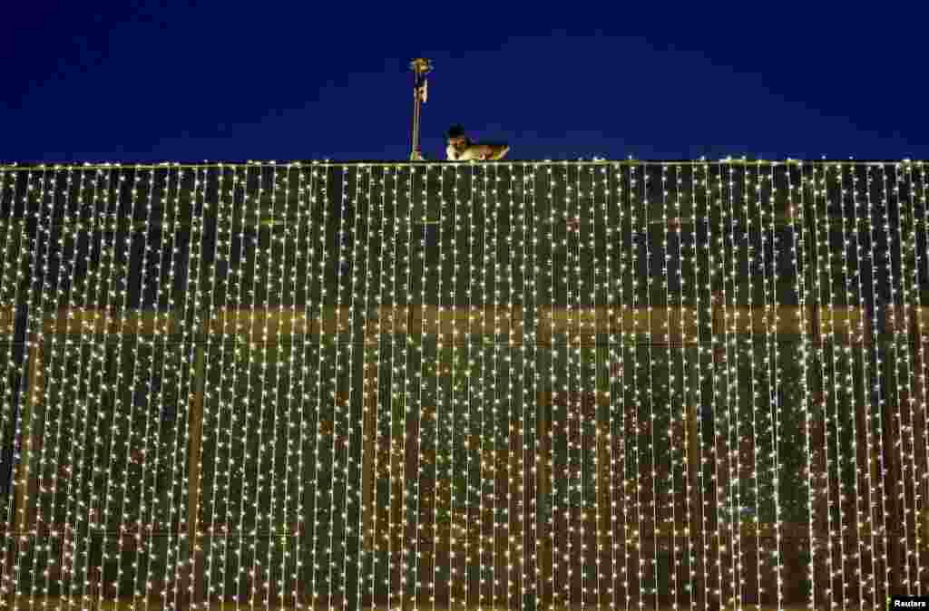 A man inspects the bulbs on a building ahead of Christmas Day celebrations and the holiday season in Colombo, Sri Lanka.