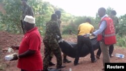 Du personnel de l'armée kenyane ainsi que des volontaires de la Croix rouge transportent des de personnes tuées dans un village à Korome, non loin de la frontière avec la ville de Mandera, 2 décembre 2014.