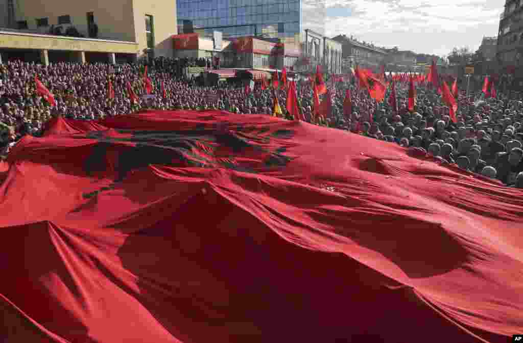 A massive Albanian flag is carried on top of tens of thousands of Kosovo opposition supporters during anti-government rally in Kosovo&#39;s capital Pristina.