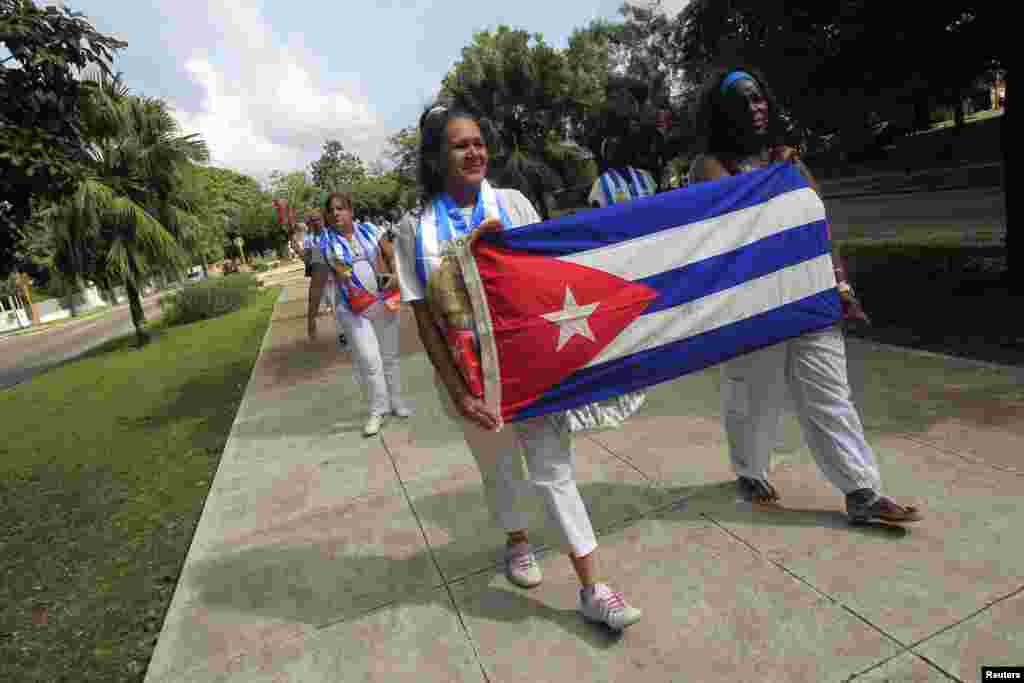 Recently released dissidents Aide Gallardo (left) and Sonia Garro hold the Cuban national flag during a march in Havana, Cuba, Jan. 11, 2015.