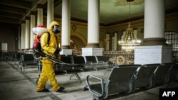 FILE - A serviceman of Russia's Emergencies Ministry, wearing protective gear, disinfects Kievsky railway terminal amid the COVID-19 pandemic in Moscow, September 2021.