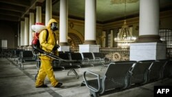 Seorang petugas menyemprotkan desinfektan ke stasiun kereta bawah tanah Kievsky di tengah lonjakan kasus COVID-19 di Moskow, Rusia. 