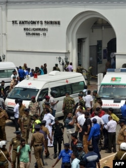 Ambulances are seen outside the church premises with gathered people and security personnel following a blast at the St. Anthony's Shrine in Kochchikade, Colombo, April 21, 2019.