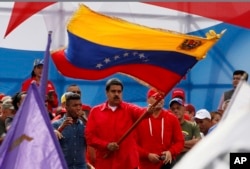 FILE - Venezuela's President Nicolas Maduro waves the Venezeulan flag during a rally in Caracas, Venezuela, July 27, 2017.