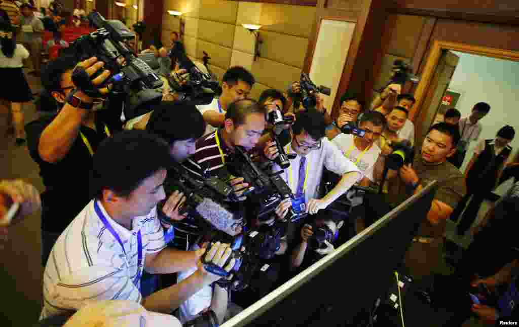 Journalists film a screen displaying a court&#39;s microblog page showing disgraced Chinese politician Bo Xilai standing trial, in Jinan, Shandong province. Bo appeared in public for the first time in more than a year to face trial in eastern China, the final chapter of the country&#39;s most politically charged case in more than three decades.