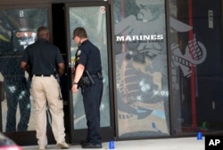 Police officers enter the Armed Forces Career Center through a bullet-riddled door after a gunman opened fire on the building in Chattanooga, Tennessee, July 16, 2015.