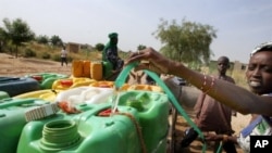 A woman fills cans of water in Touba, Senegal, 01 Nov 2007 (file photo)