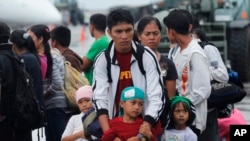 A family of typhoon survivors wait for a flight out of Tacloban.