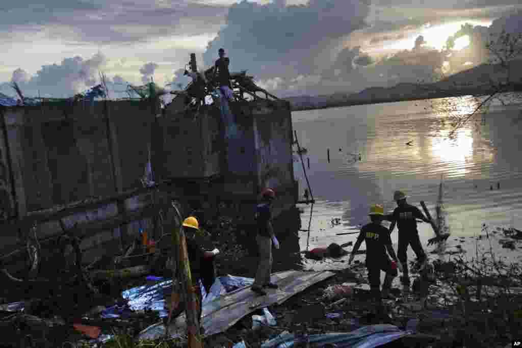 A rescue team wades into flood waters to retrieve a body in Tacloban, central Phillipines, Nov. 13, 2013. 