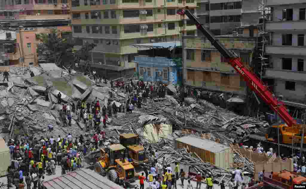 An aerial view shows bystanders watching rescuers search for survivors amongst the rubble of a collapsed building in the Kariakoo district of central Dar es Salaam, Tanzania, March 29, 2013.