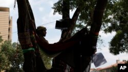 A protester rests in a hammock hanging from a tree at Gezi Park in Istanbul, June 4, 2013.