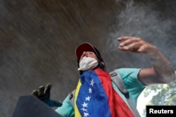 An opposition supporter clashes with riot police while rallying against President Nicolas Maduro in Caracas, Venezuela, May 4, 2017.