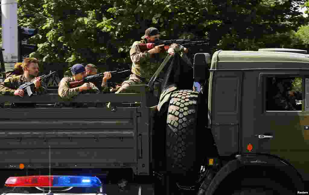 A military truck with armed pro-Russian militants drives through a police checkpoint toward the airport at Donetsk, Ukraine, May 26, 2014. 