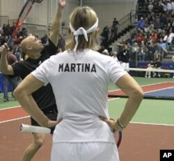 Andre Agassi warms up before tennis fundraiser as Martina Navratilova looks on
