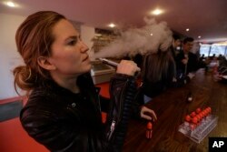 FEATURE - Talia Eisenberg, co-founder of Henley Vaporium, is using his vaping device in New York on February 20, 2014.