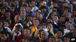 Buddhist devotees listen to the Tibetan spiritual leader the Dalai Lama, unseen, as he addresses Tibetan devotees during the Kalachakra Buddhist festival in the town of Bodh Gaya, believed to be the place where Buddha attained enlightenment, Bihar, India,