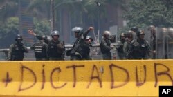 FILE - A Venezuelan National Guard officer throws a tear gas grenade towards demonstrators during a protest in Caracas, Venezuela, April 10, 2017. 