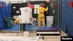 MSF volunteer receives training on how to handle personal protective equipment during Ebola response courses, Brussels, Oct., 15, 2014.