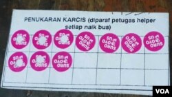 Kartu dengan sticker khusus diberikan kepada masyarakat setelah menukar sejumlah gelas dan botol plastik bekas, petugas akan melubangi sticker dan mengganti dengan tiket Suroboyo Bus (Petrus/VOA).