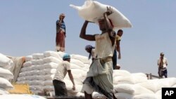FILE - Men deliver U.N. World Food Programme (WFP) aid in Aslam, Hajjah, Yemen, Sept. 21, 2018.