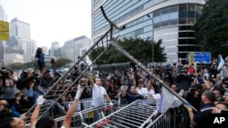 Workers start clearing away barricades at an occupied area outside government headquarters in Hong Kong, Nov. 18, 2014. 