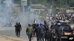 Ivory Coast police loyal to incumbent president Laurent Gbagbo face supporters of Alassane Ouattara, who has claimed to have won last month's presidential election, during a protest in a street in Abidjan on Dec 16, 2010