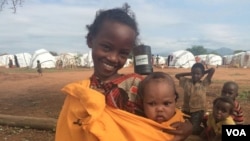Machi, an Ethiopian refugee in Kenya's Dambala Fachana camp, carries her youngest sister, Lelo. They came to the camp with their family in March. (D. Gelmo/VOA)