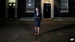 FILE - Britain's Prime Minister Theresa May delivers remarks on the draft Brexit deal outside 10 Downing Street in London, Nov. 14, 2018.