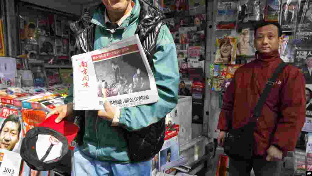 2013年1月10日,一位男士在廣州《南方周末》總部附近的一處報刊亭展示最新版的 《南方周末》。