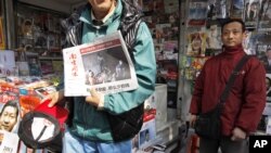 A man displays a latest edition of Southern Weekly newspaper at a newsstand near the headquarters of the newspaper in Guangzhou, Guangdong province, China, January 10, 2013.