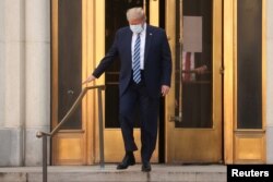 U.S. President Donald Trump walks out the front doors and down the front steps of Walter Reed National Military Medical Center after a fourth day of treatment for the coronavirus disease (COVID-19) while returning to the White House in Washington.