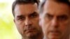 Flavio Bolsonaro, son of Brazil's President-elect Jair Bolsonaro is seen behind him at the transition government building in Brasilia, Nov. 27, 2018. 