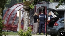 Gendarmes and investigators stand at the camp site where the slain British family were holidaying in Saint Jorioz, near Annecy, September 6, 2012. 