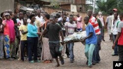 Men carry a dead body in the Nyakabiga neighborhood of Bujumbura, Burundi, where a number of people were found shot dead a day after the government said an unidentified group had carried out coordinated attacks on three military installations, Dec. 12, 2015.