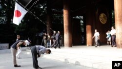 FILE - People bow deeply at the Yasukuni Shrine in Tokyo, August 15, 2013. 