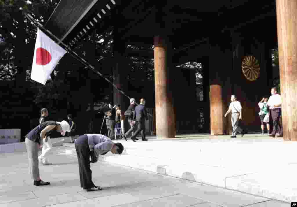 People bow deeply at the Yasukuni Shrine in Tokyo, August 15, 2013. 