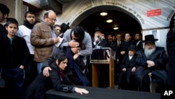 Family and relatives of Yoav Hattab, a Jewish victim of the attack on a kosher grocery store in Paris, gather around a symbolic coffin for his funeral procession in the city of Bnei Brak near Tel Aviv, Israel, Jan. 13, 2015. 