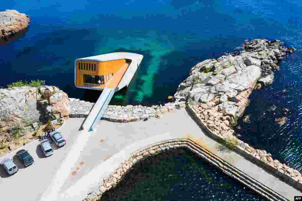 This photo shows an aerial view of Under, a restaurant that is semi-submerged beneath the waters of the North Sea in Lindesnes near Kristiansand, some 400 km south west of Oslo. The new restaurant serves up Poseiden&#39;s delicacies with a unique view, in an architectural showpiece that stretches five meters (15 feet) underwater. The restaurant is a 34-meter monolith designed by Norwegian firm Snohetta, known for its celebrated buildings such as the Oslo Opera and the 9/11 Memorial Pavilion in New York.