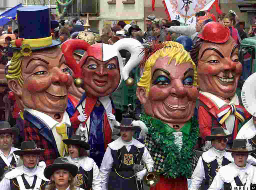 Carnival revelers wearing huge papier-mache heads called the 'Schwellkoepp' (swollen heads) march at the beginning of the annual carnival parade in Mainz, western Germany, (AP Photo)