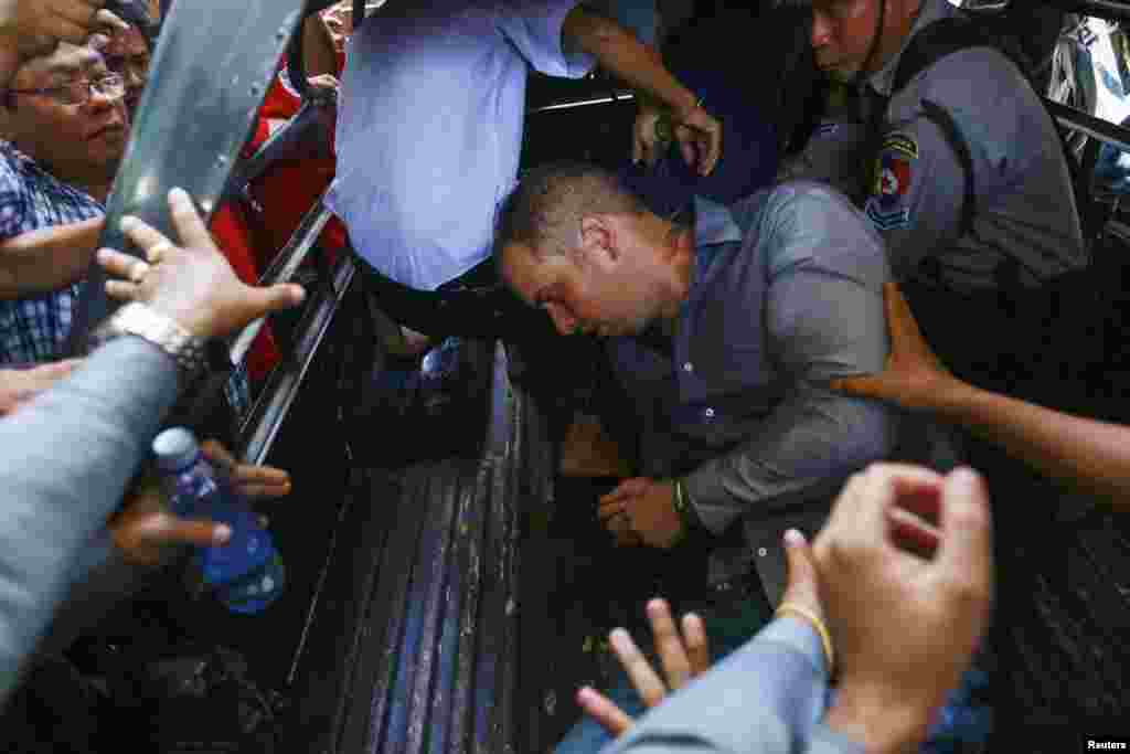 Phil Blackwood, a bar manager from New Zealand, falls into a police vehicle as he is taken away after being sentenced to two and half years in prison, at Bahan township court in Yangon. Blackwood was found guilty along with two Myanmar citizens, bar owner Tun Thurein and manager Htut Ko Ko Lwin, of insulting religion after publishing a psychedelic image of Buddha wearing headphones to promote his bar in Yangon.
